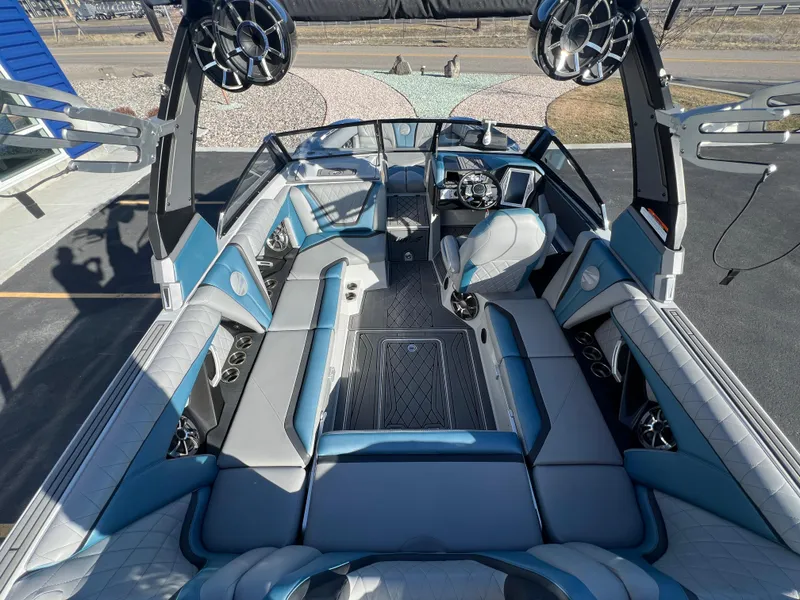 Slide: The Image of 2018 Tigé RZX3 boat interior with blue and gray seating, advanced sound system, and sleek design. - 13