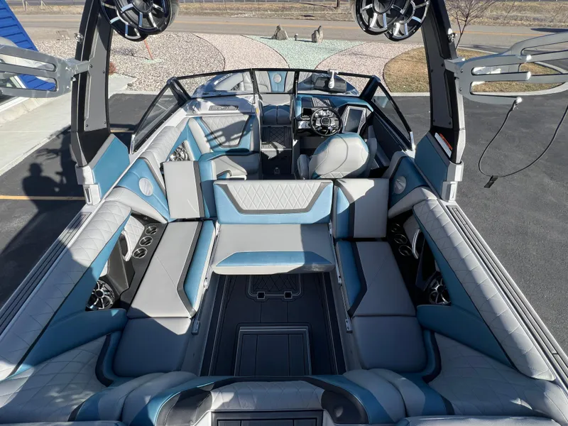 Slide: The Image of 2018 Tigé RZX3 boat interior with blue and gray seating, speakers, and steering wheel. - 14