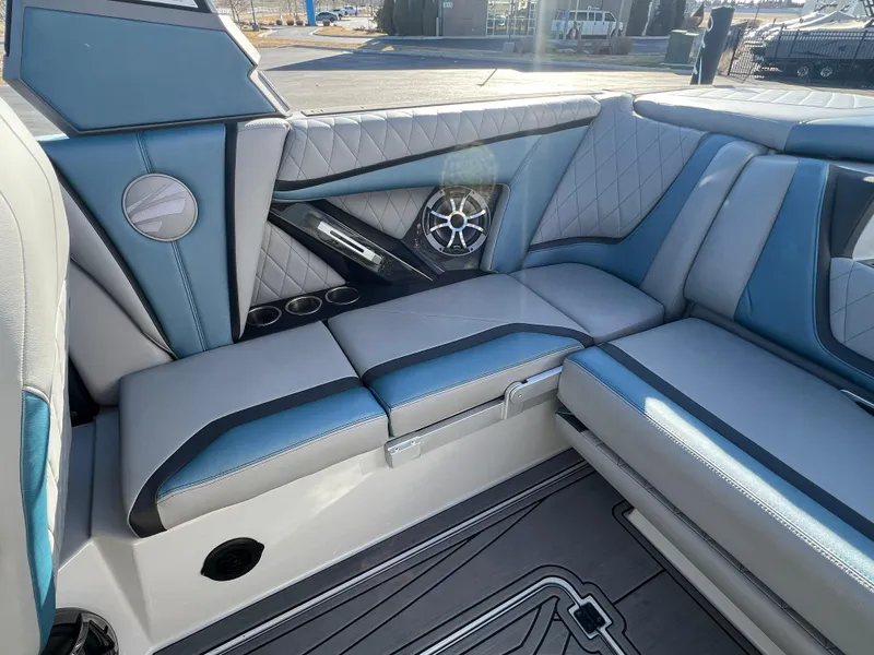 Slide: The Image of 2018 Tigé RZX3 boat interior with blue and gray seating, speaker, and cup holders. - 17
