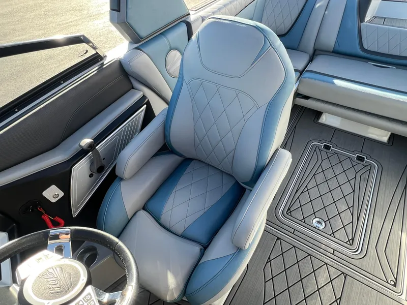 Slide: The Image of 2018 Tigé RZX3 boat interior with blue and gray seating and steering wheel. - 19