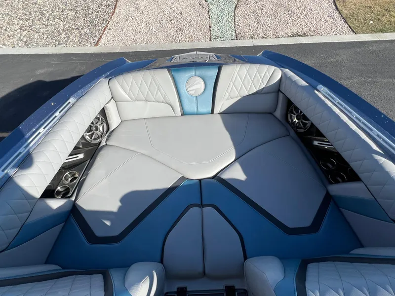 Slide: The Image of 2018 Tigé RZX3 boat interior with luxurious gray and blue seating, cup holders, and speakers. - 21