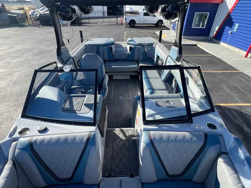 Slide: The Image of 2018 Tigé RZX3 boat interior with blue and gray seating, open windshield, and modern design. - 22