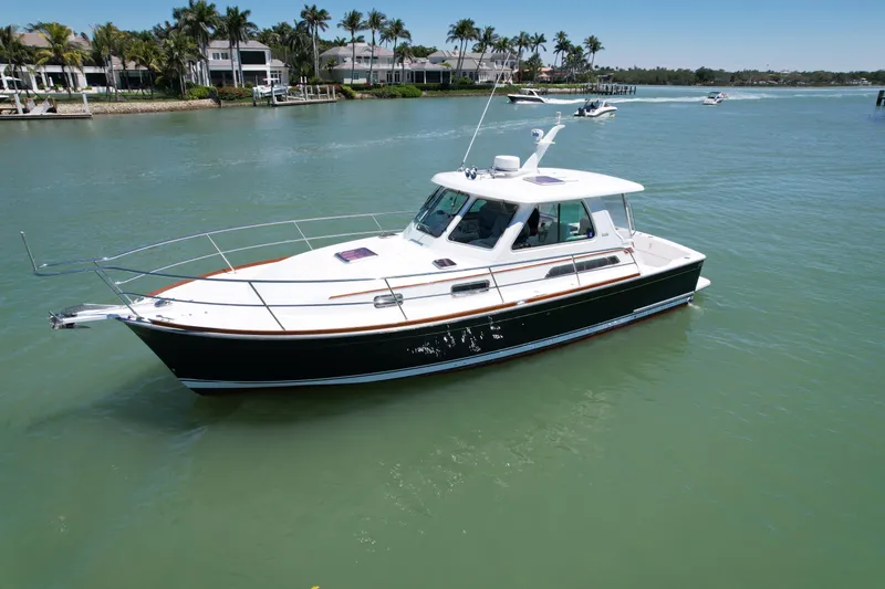 Slide: The Image of 2009 Sabre 34 Express yacht cruising on calm waters near a coastal area. - 0