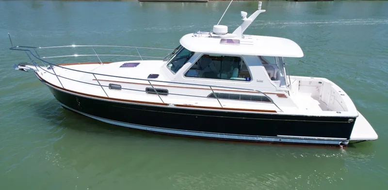 Slide: The Image of 2009 Sabre 34 Express boat on calm water, featuring sleek design and white cabin. - 1