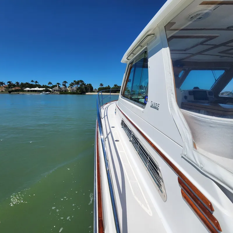 Slide: The Image of 2009 Sabre 34 Express yacht cruising on calm waters under clear blue skies. - 10