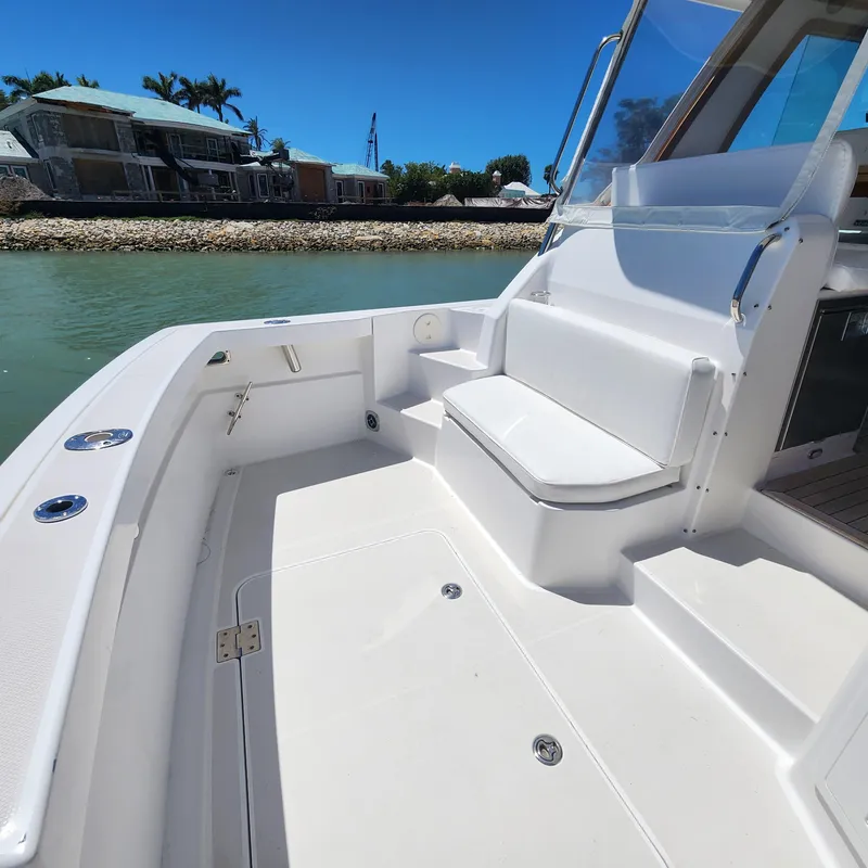 Slide: The Image of 2009 Sabre 34 Express boat deck with seating, docked by waterfront homes. - 19