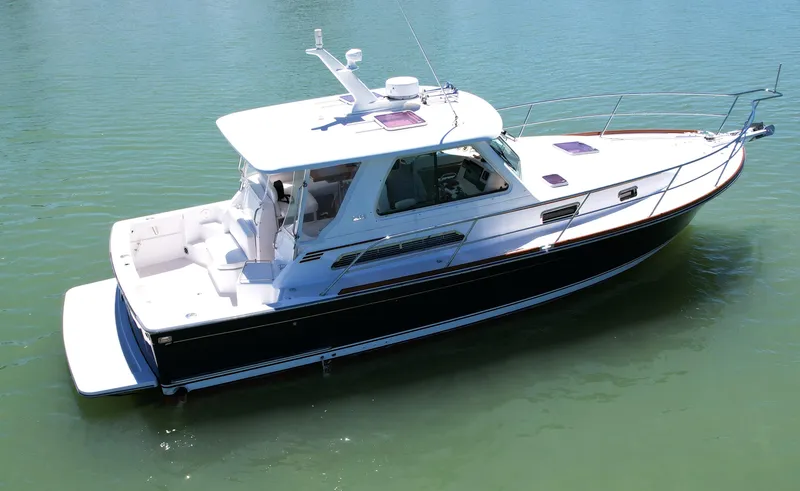 Slide: The Image of 2009 Sabre 34 Express boat on calm water, featuring sleek design and spacious deck. - 2