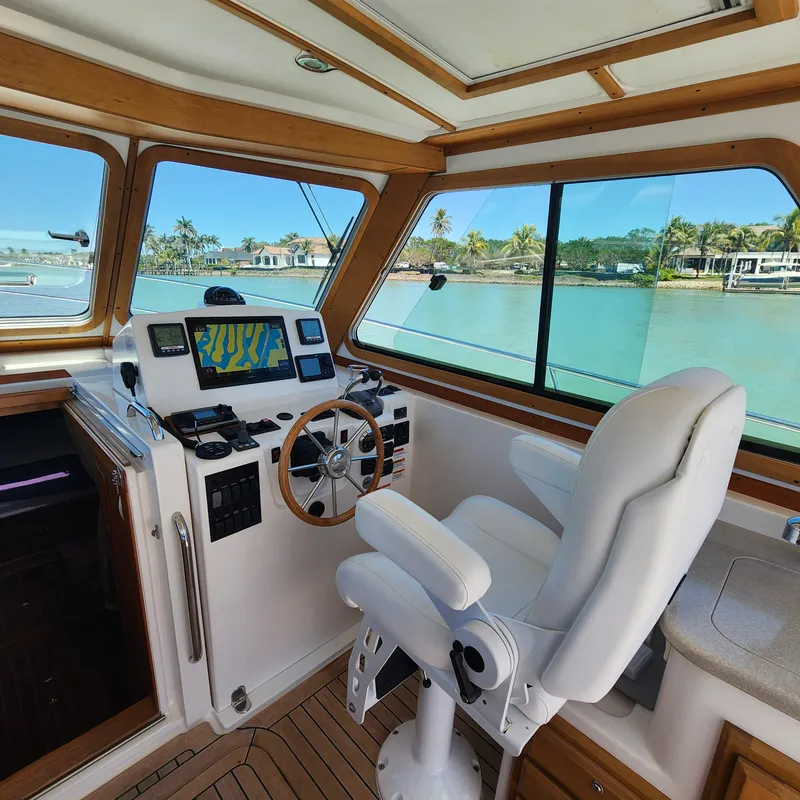 Slide: The Image of 2009 Sabre 34 Express helm with navigation equipment, overlooking serene waterfront view. - 22