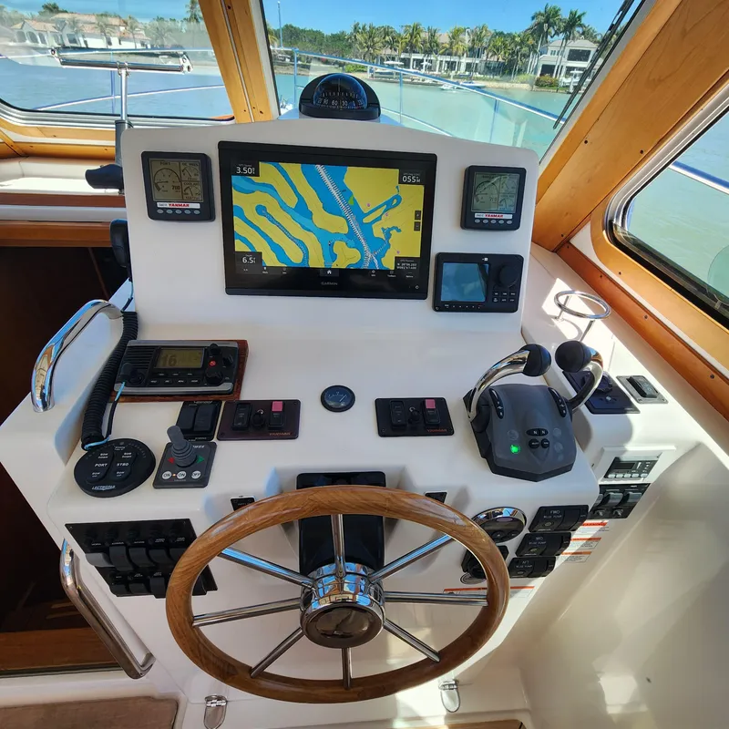 Slide: The Image of Control panel of a 2009 Sabre 34 Express boat with navigation equipment and steering wheel. - 23