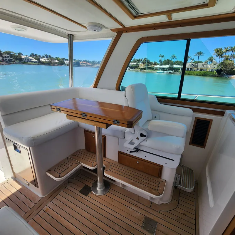 Slide: The Image of Interior of 2009 Sabre 34 Express yacht with seating and table, overlooking serene waters. - 25