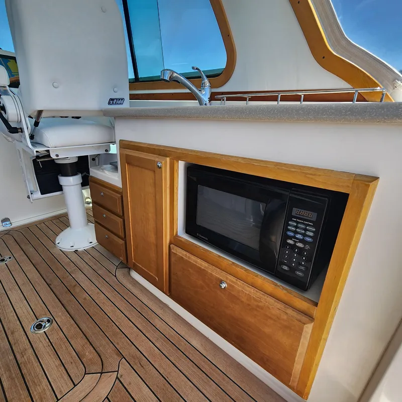 Slide: The Image of 2009 Sabre 34 Express interior with microwave, sink, and seating on wooden flooring. - 30