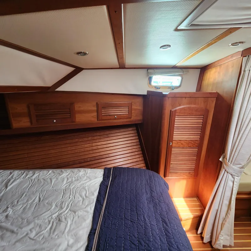Slide: The Image of 2009 Sabre 34 Express cabin with wooden interior and cozy bedding. - 39
