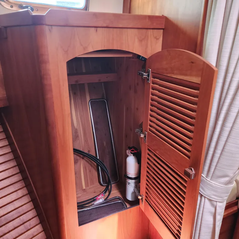 Slide: The Image of Open wooden cabinet on 2009 Sabre 34 Express boat, showing interior storage space. - 42