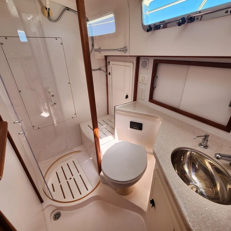 Slide: The Image of 2009 Sabre 34 Express yacht bathroom with shower, toilet, sink, and window. - 48
