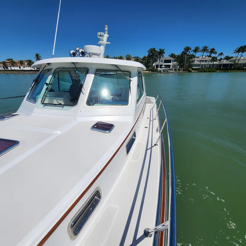 Slide: The Image of 2009 Sabre 34 Express yacht on calm water, clear sky, and palm trees in the background. - 5