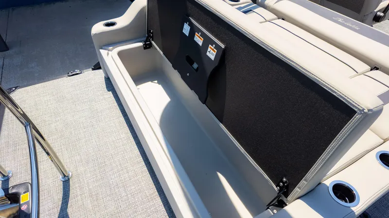 Slide: The Image of 2024 Barletta ARIA 22UC boat storage compartment with open lid and cup holders. - 17