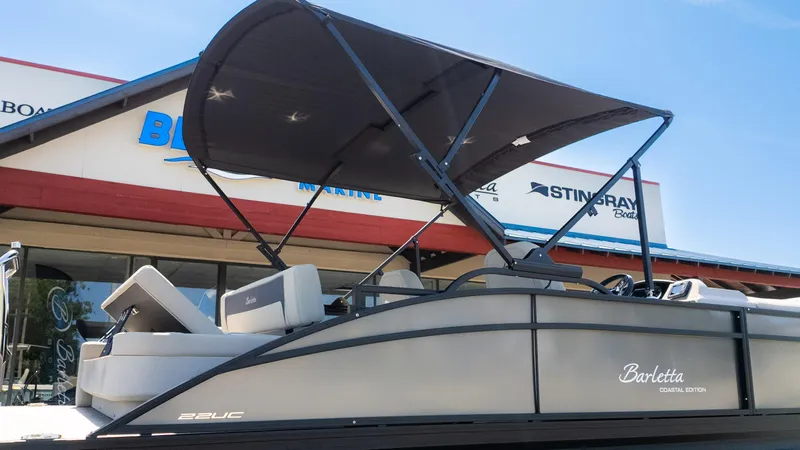 Slide: The Image of 2024 Barletta ARIA 22UC pontoon boat with canopy, displayed at a marine dealership. - 34