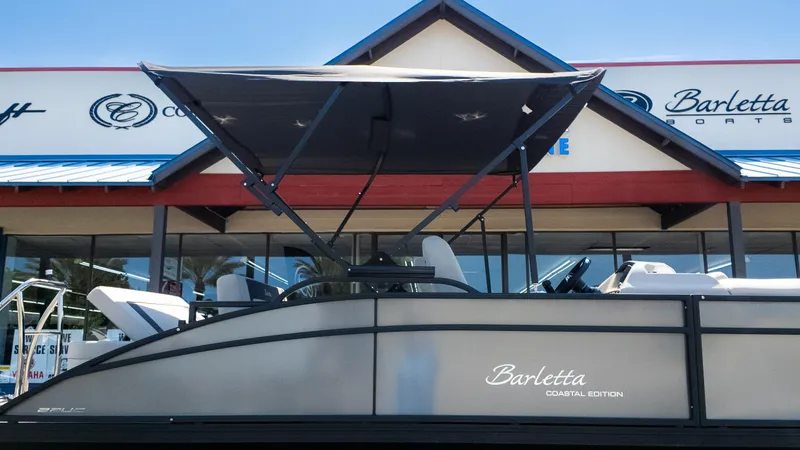 Slide: The Image of 2024 Barletta ARIA 22UC pontoon boat displayed at dealership, featuring a sleek design and canopy. - 36