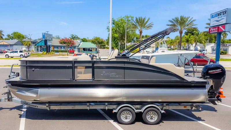 Slide: The Image of 2024 Barletta ARIA 22UC pontoon boat on trailer, parked at Bluewater Marine. - 5