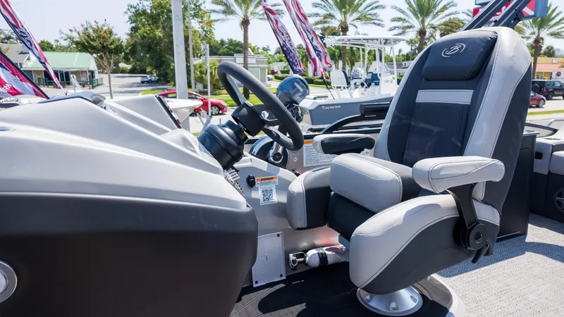 Slide: The Image of Captain's chair and helm of 2025 Barletta Cabrio 24UE boat, featuring sleek design and controls. - 22