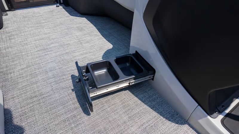 Slide: The Image of 2025 Barletta Cabrio 24UE interior with pull-out storage tray on carpeted floor. - 26