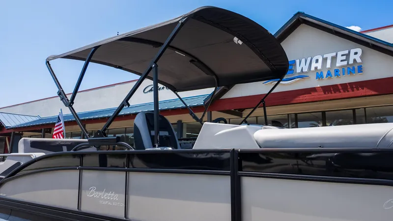 Slide: The Image of 2025 Barletta Cabrio 24UE pontoon boat displayed at a marine dealership. - 28
