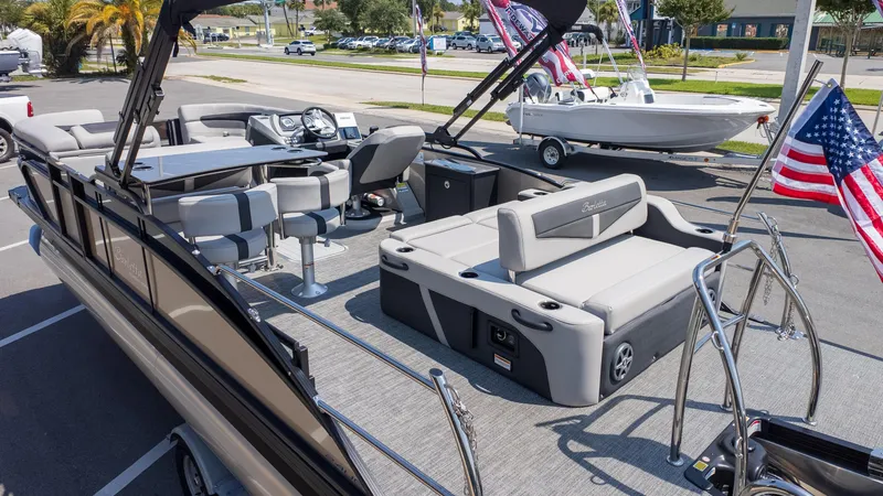 Slide: The Image of 2025 Barletta Cabrio 24UE pontoon boat with spacious seating and American flag. - 5