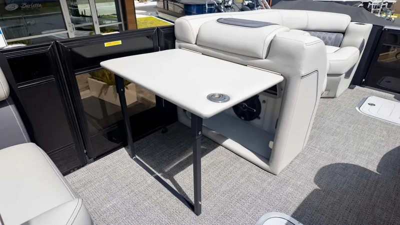 Slide: The Image of 2025 Barletta Lusso 23M boat interior with foldable table and plush seating. - 17