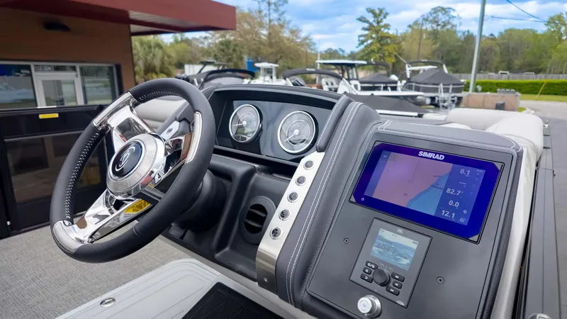 Slide: The Image of 2025 Barletta Lusso 23M boat dashboard with steering wheel and Simrad navigation display. - 27