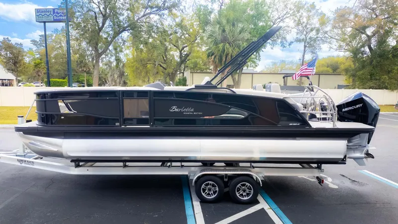 Slide: The Image of 2025 Barletta Lusso 23M pontoon boat on trailer, parked outdoors. - 5