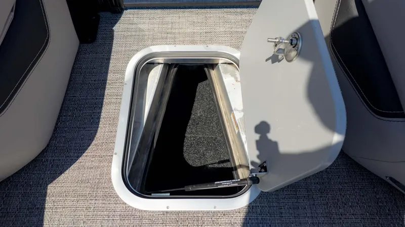Slide: The Image of Open storage compartment on 2025 Barletta Lusso 25UE boat, featuring carpeted interior. - 19