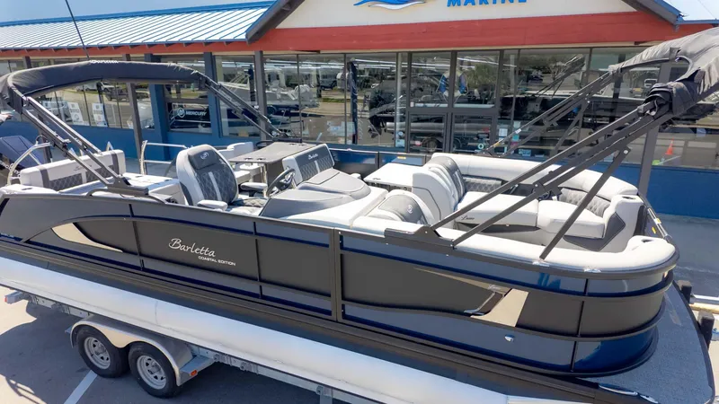 Slide: The Image of 2025 Barletta Lusso 25UE pontoon boat displayed on a trailer outside a marine dealership. - 3