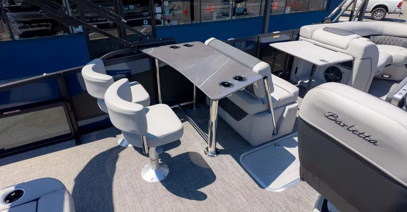 Slide: The Image of 2025 Barletta Lusso 25UE pontoon boat interior with seating and table setup. - 8