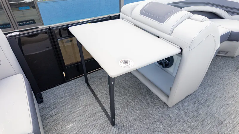 Slide: The Image of 2025 Barletta Corsa 23U boat interior with foldable table and cushioned seating. - 14