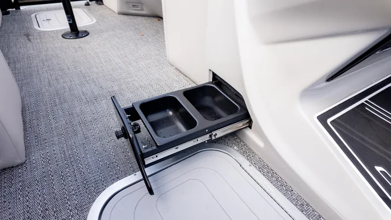 Slide: The Image of 2025 Barletta Corsa 23U interior with pull-out cup holder on carpeted floor. - 21
