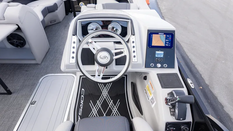 Slide: The Image of 2025 Barletta Corsa 23U boat dashboard with steering wheel and navigation display. - 23