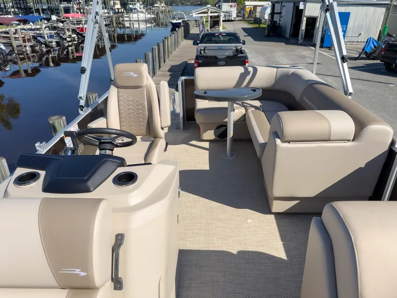 Slide: The Image of 2024 Bennington 188 SL pontoon boat interior with beige seating and steering console. - 12
