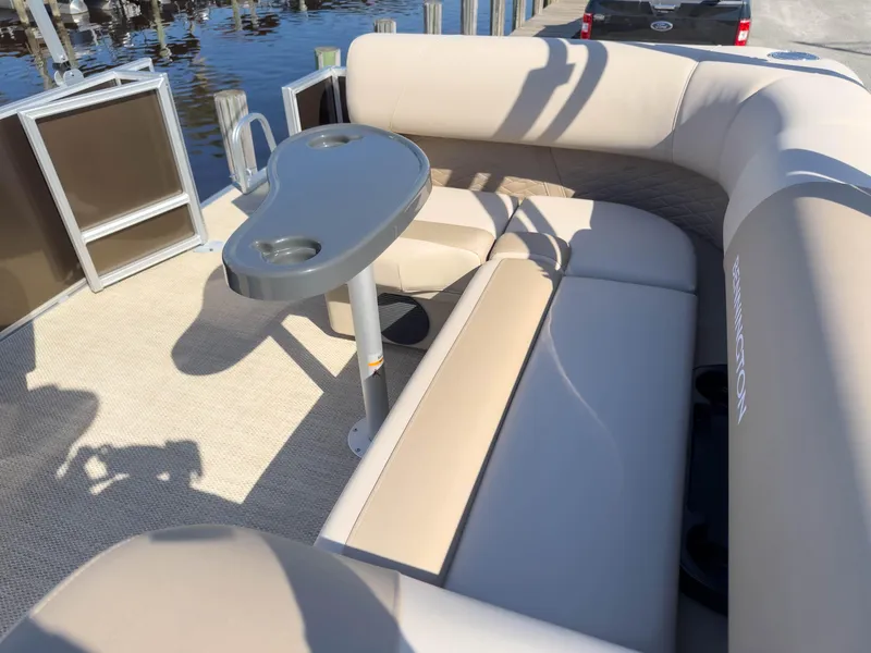 Slide: The Image of 2024 Bennington 188 SL pontoon boat with beige seating and a small table. - 13