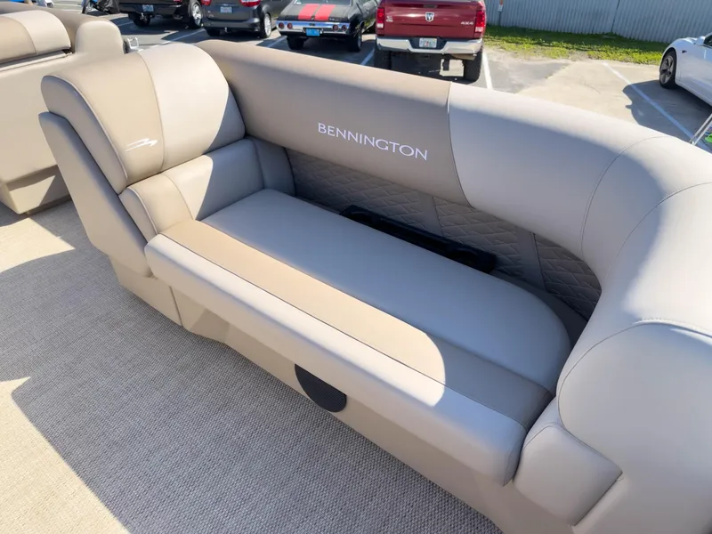 Slide: The Image of 2024 Bennington 188 SL boat interior with beige seating and logo. - 17