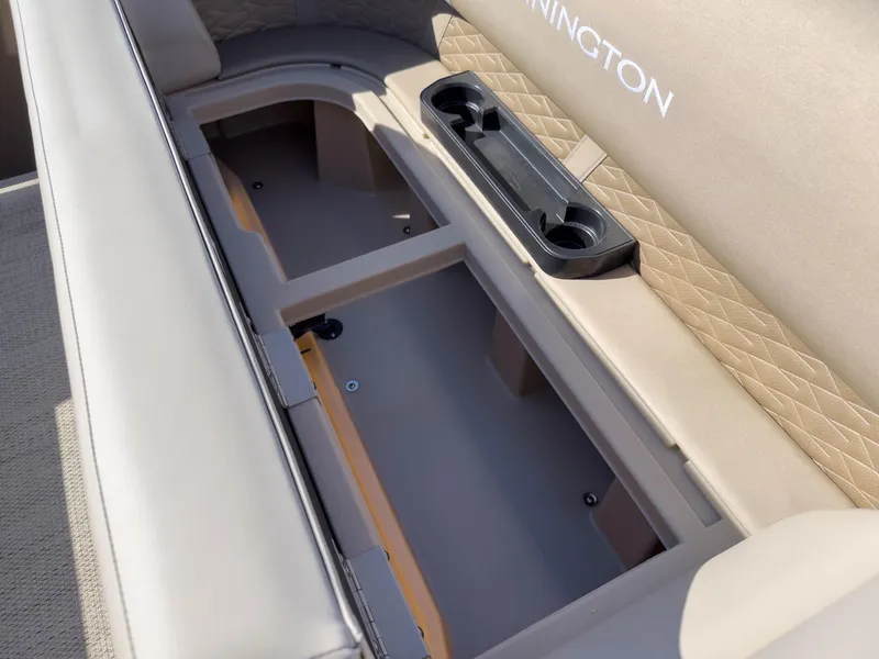 Slide: The Image of 2024 Bennington 188 SL boat seat storage with cup holders and beige upholstery. - 21