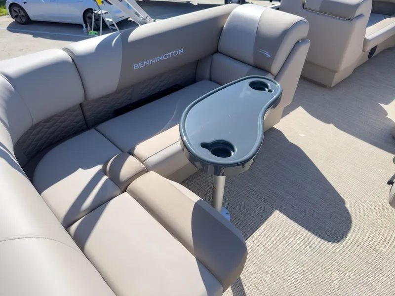 Slide: The Image of 2024 Bennington 188 SL pontoon boat interior with plush seating and a central table. - 28