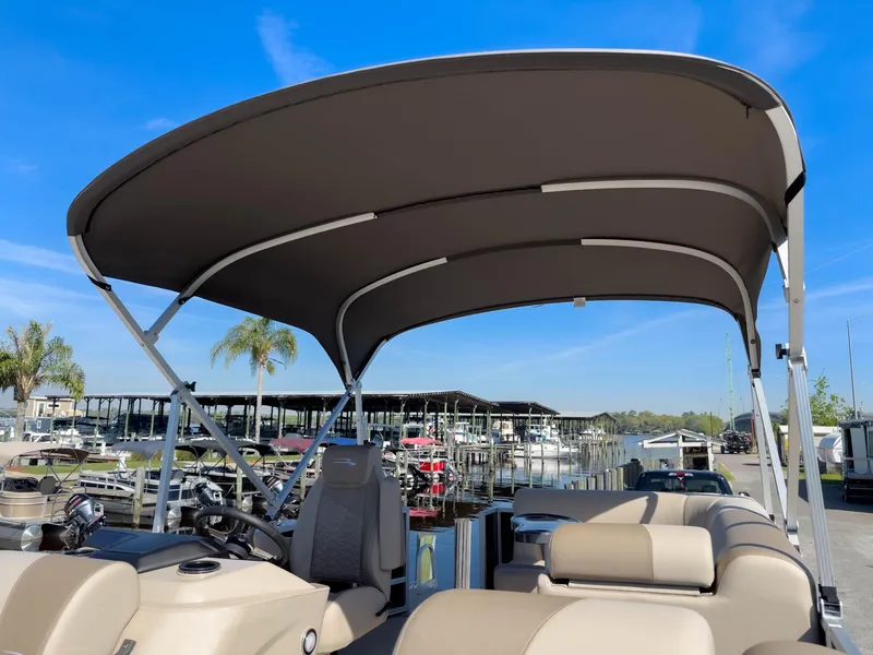 Slide: The Image of 2024 Bennington 188 SL pontoon boat with canopy, docked at marina under clear blue sky. - 29