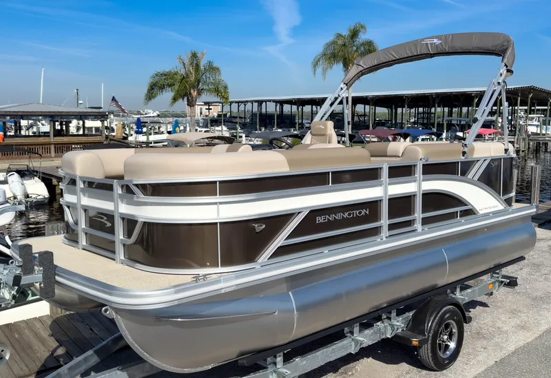 Slide: The Image of 2024 Bennington 188 SL pontoon boat docked at a marina with palm trees. - 3