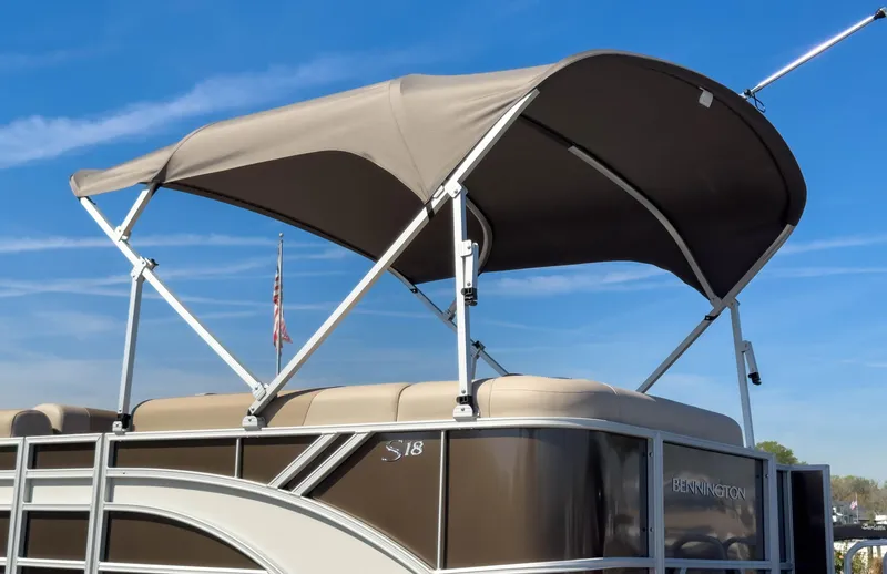 Slide: The Image of 2024 Bennington 188 SL pontoon boat with canopy under clear blue sky. - 30