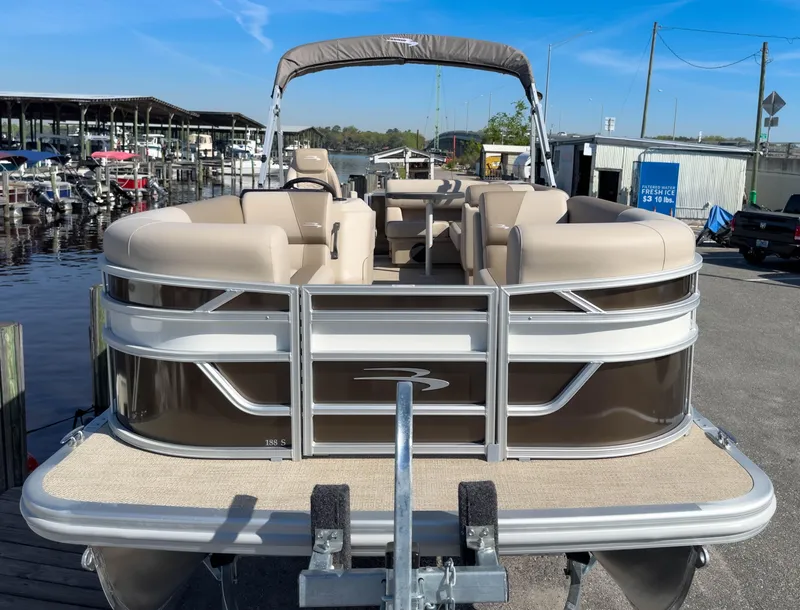 Slide: The Image of 2024 Bennington 188 SL pontoon boat docked at marina under clear blue sky. - 4