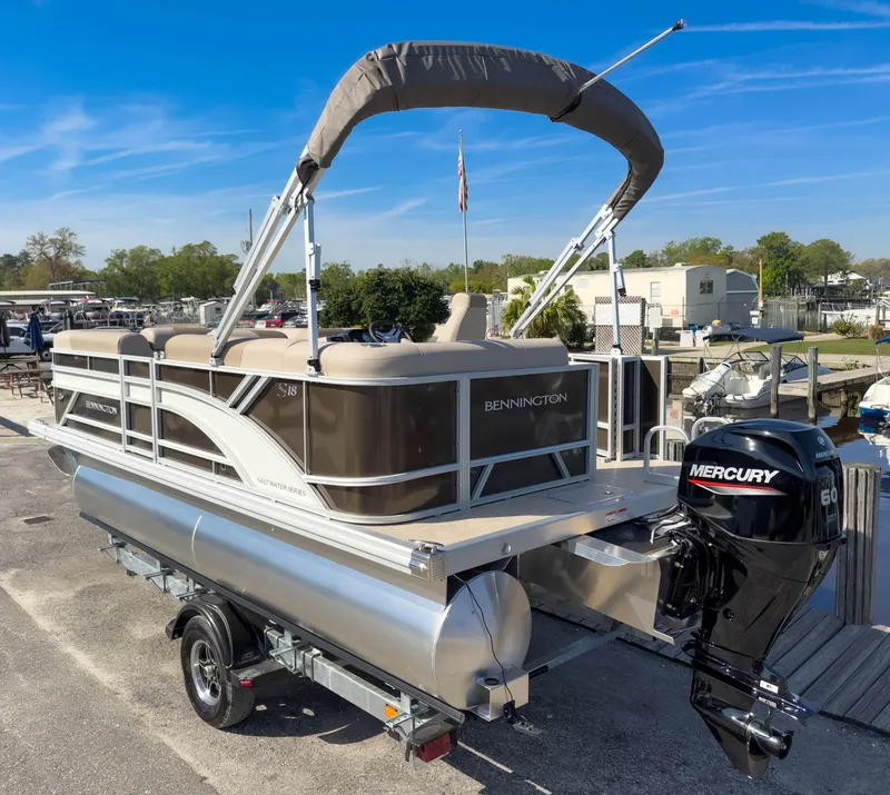 Slide: The Image of 2024 Bennington 188 SL pontoon boat with Mercury engine on trailer, dockside. - 8