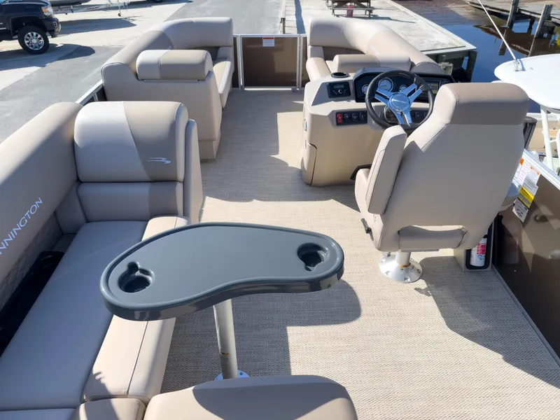 Slide: The Image of 2024 Bennington 188 SL pontoon boat interior with beige seating and steering console. - 9