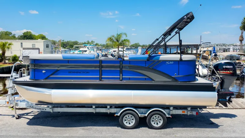 Slide: The Image of 2024 Bennington 20 SSR pontoon boat on trailer, dockside with clear blue sky. - 1