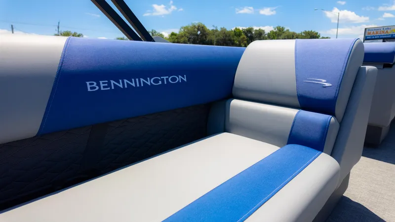 Slide: The Image of 2024 Bennington 20 SSR boat interior with blue and gray seating under sunny sky. - 14