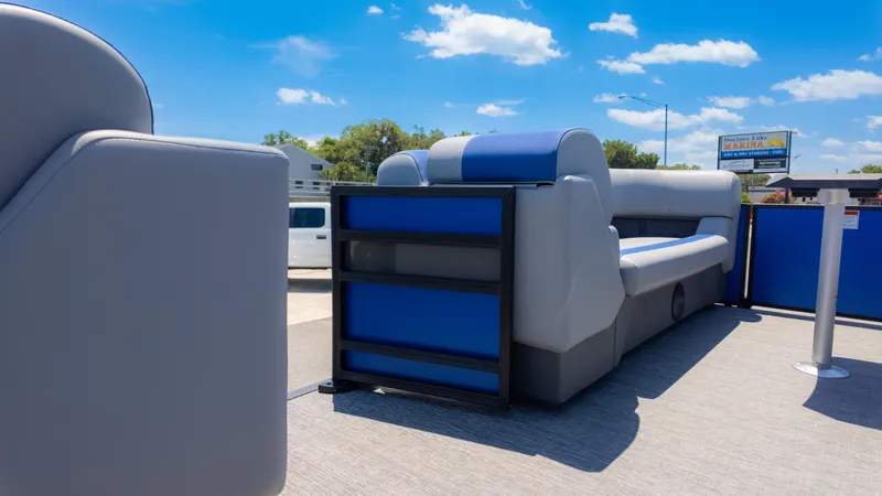 Slide: The Image of 2024 Bennington 20 SSR pontoon boat with blue and gray seating under a clear sky. - 18